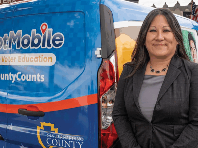 Registrar of Voters Stephanie Shea stands next to the newly unveiled BallotMobile.